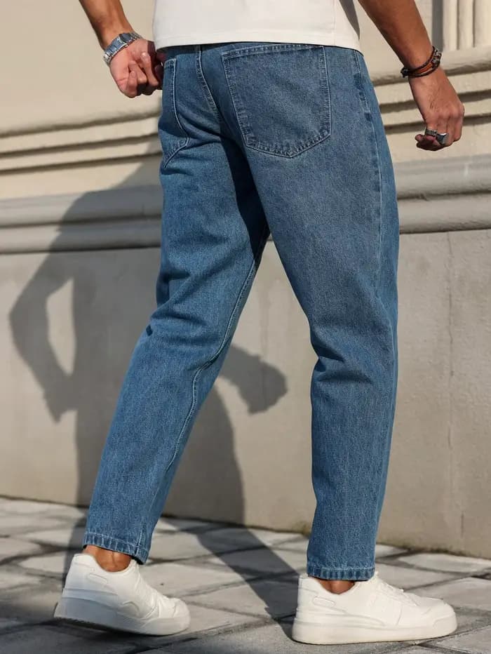 Les jeans pour hommes sont fabriqués en tissu denim bleu classique avec une coupe ample