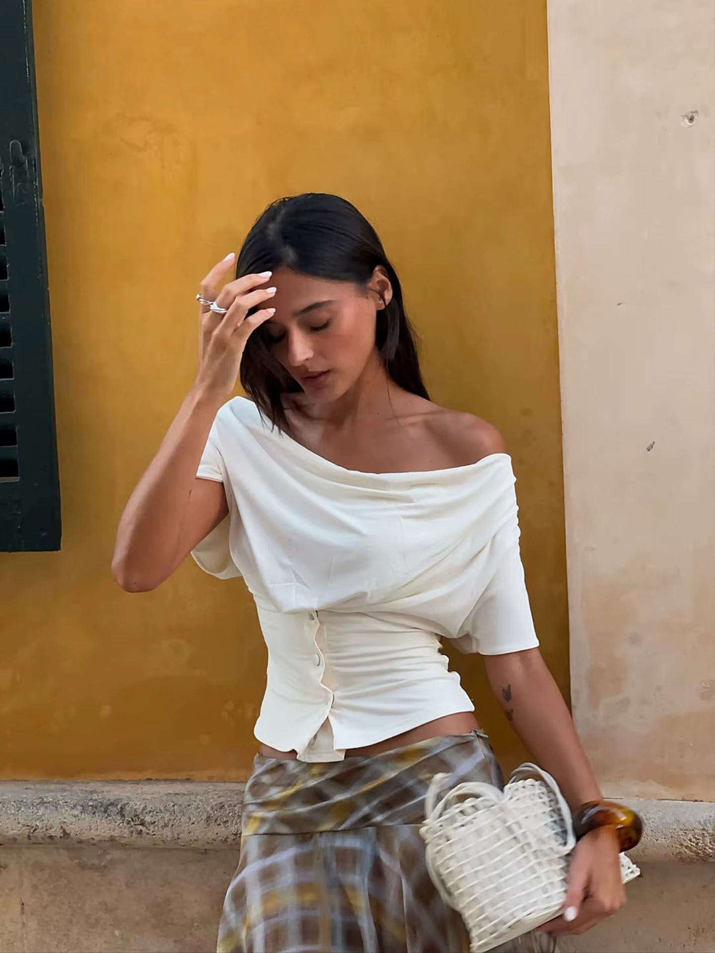 T-shirt beige en jean à taille cintrée, haut noir asymétrique à une épaule et manches courtes