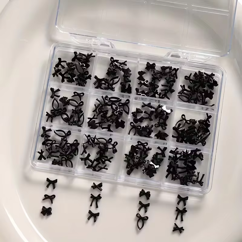 Une boîte de 12 accessoires d'art d'ongle à nœud coloré et doux, en résine, parfaits pour les décora