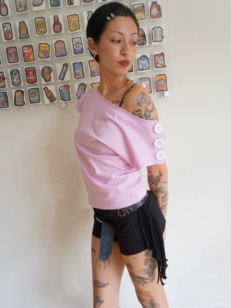 T-shirt rose à épaules dénudées pour femme avec encolure asymétrique et détail boutonné sur la manch